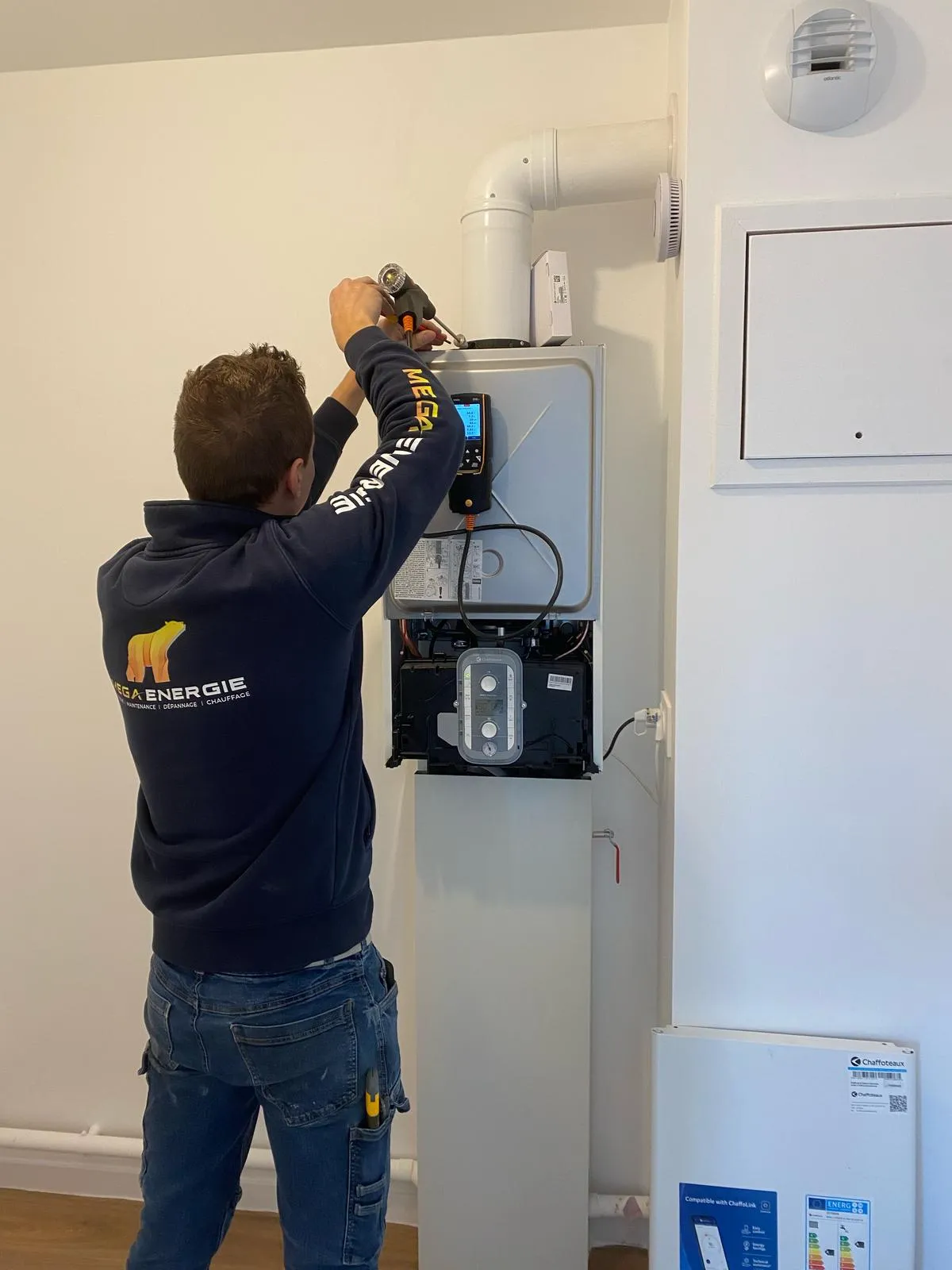 Technicien MEGA ÉNERGIE effectuant la maintenance et le diagnostic technique d'une chaudière murale à gaz Chaffoteaux aux Sables d'Olonne.