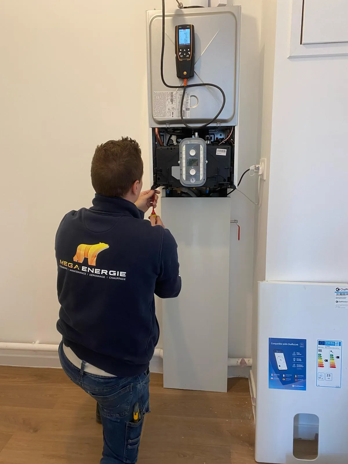 Technicien MEGA ÉNERGIE effectuant la maintenance et le diagnostic technique d'une chaudière murale à gaz Chaffoteaux aux Sables d'Olonne.
